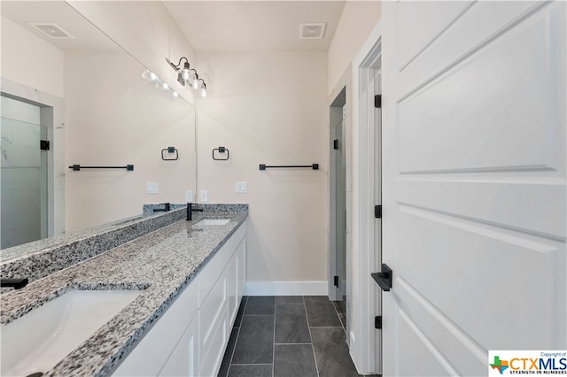 bathroom featuring vanity, a shower with shower door, and tile patterned flooring