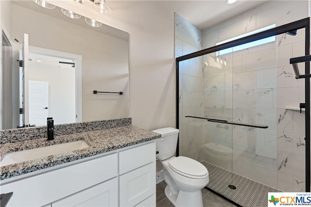 bathroom with vanity, tile patterned floors, toilet, and a shower with door