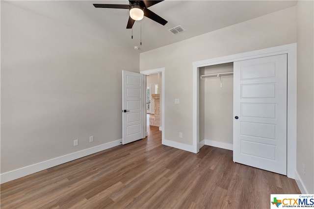 unfurnished bedroom with hardwood / wood-style flooring, ceiling fan, and a closet