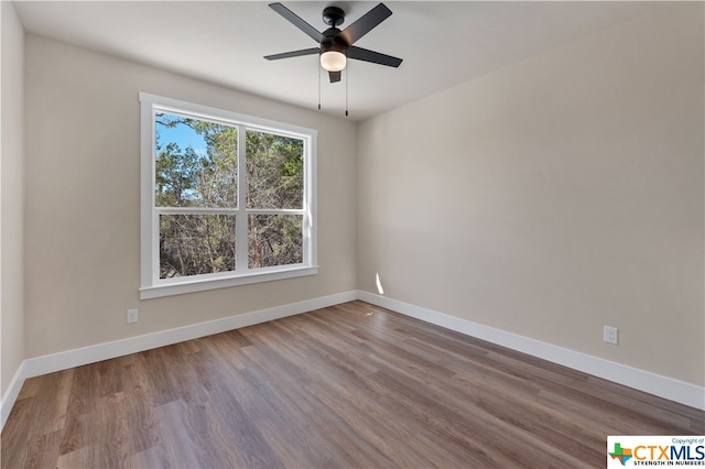 empty room with hardwood / wood-style floors and ceiling fan