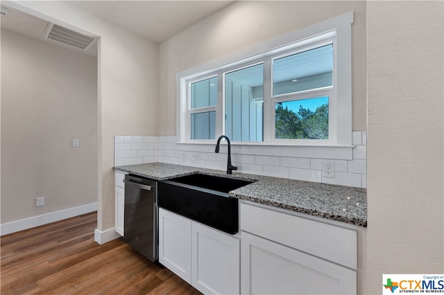 kitchen featuring white cabinetry, hardwood / wood-style floors, stone counters, and backsplash