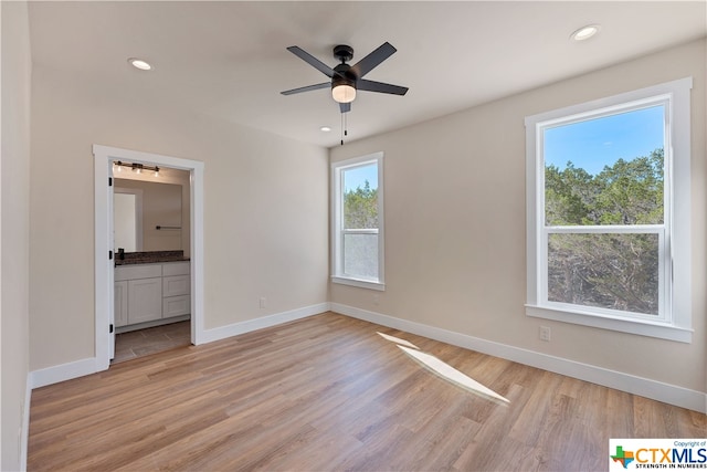 unfurnished bedroom with ensuite bathroom, light hardwood / wood-style floors, and ceiling fan