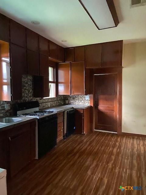 409 E Hochheim St, Yoakum, TX 77995 - kitchen featuring gas range, backsplash, dark wood finished floors, and a sink