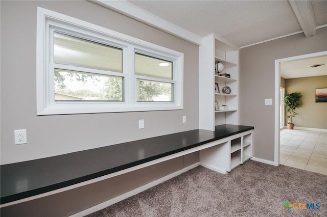 mudroom featuring light carpet, built in study area, baseboards, and ornamental molding