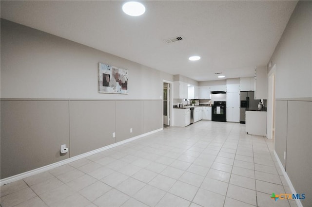 interior space with visible vents, wainscoting, and a decorative wall