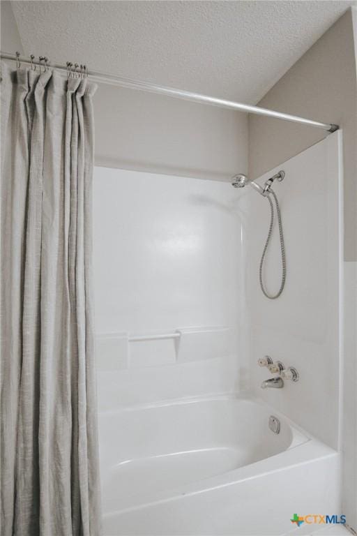 full bathroom with shower / bath combo with shower curtain and a textured ceiling