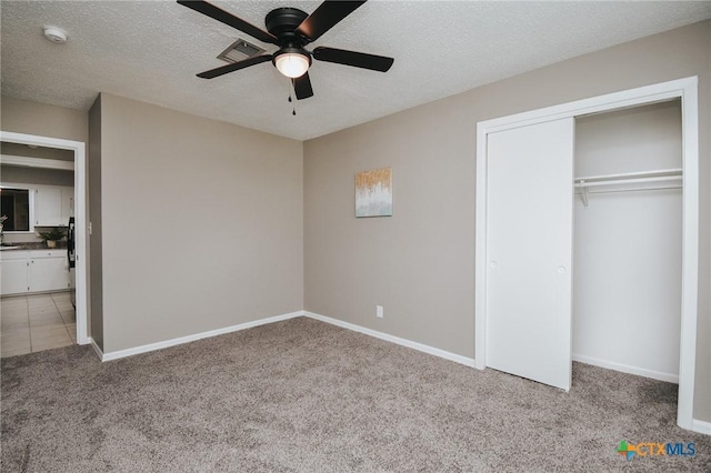 unfurnished bedroom featuring light carpet, visible vents, baseboards, and a closet