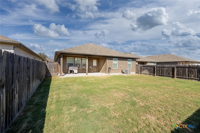 rear view of property with cooling unit, a patio area, and a lawn