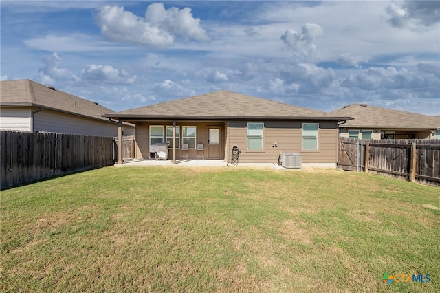 rear view of house with central AC unit, a patio area, and a yard