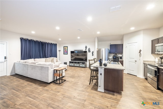 living room with light wood-type flooring and sink