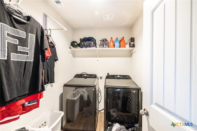 laundry area featuring washing machine and clothes dryer and hardwood / wood-style floors