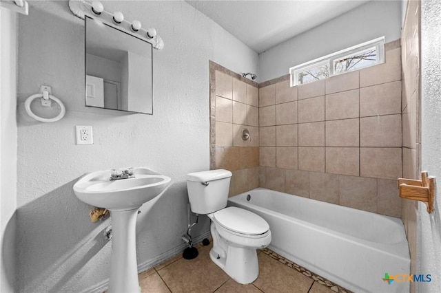 full bathroom with tiled shower / bath combo, sink, tile patterned floors, and toilet