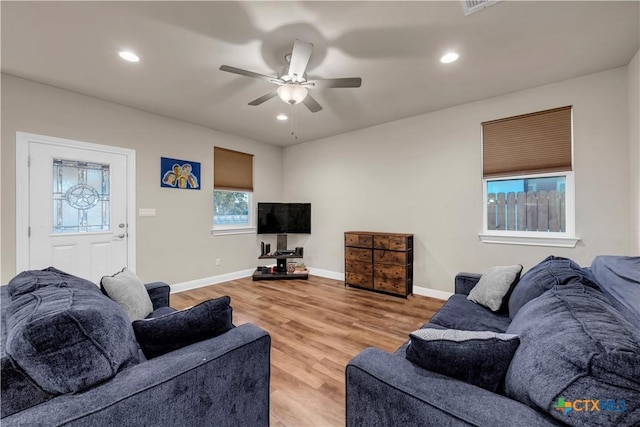 living room featuring ceiling fan and light hardwood / wood-style flooring