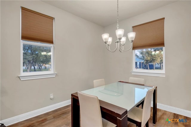 dining room featuring hardwood / wood-style flooring, a notable chandelier, and a wealth of natural light