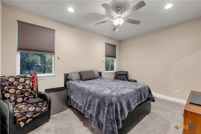 carpeted bedroom featuring ceiling fan and multiple windows