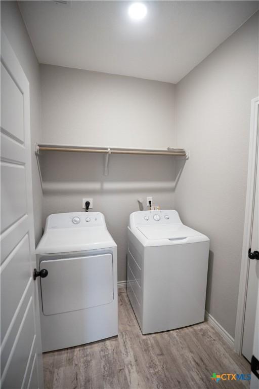 7709 Purvis St, Temple, TX 76502 - laundry area featuring separate washer and dryer, wood finished floors, and baseboards