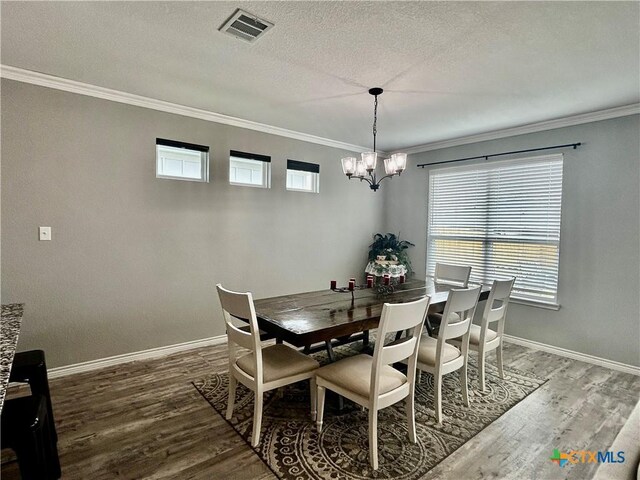 7709 Purvis St, Temple, TX 76502 - dining space with crown molding, a chandelier, wood finished floors, baseboards, and a textured ceiling