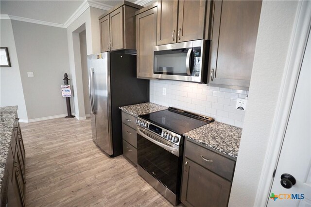 7709 Purvis St, Temple, TX 76502 - kitchen with stainless steel appliances, ornamental molding, light wood-style flooring, stone counters, and backsplash