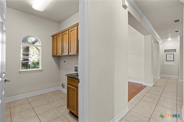 402 Prospector Trl, Harker Heights, TX 76548 - laundry area featuring electric dryer hookup, light tile patterned flooring, hookup for a washing machine, and cabinet space