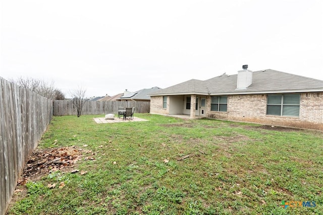 212 Oak Ridge Dr, Nolanville, TX 76559 - back of property featuring a fenced backyard, a yard, brick siding, a chimney, and a patio area