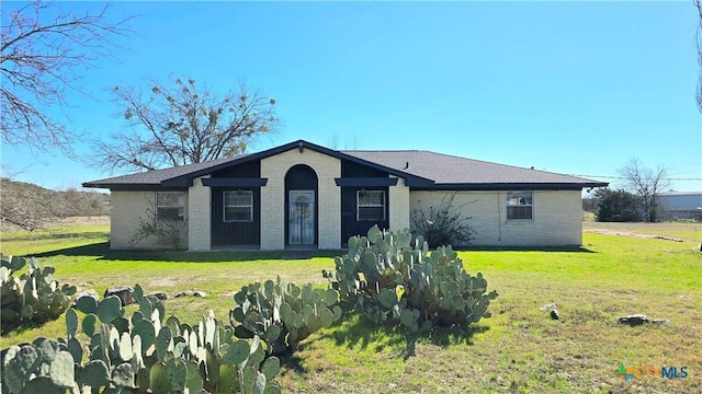 ranch-style home featuring brick siding and a front lawn