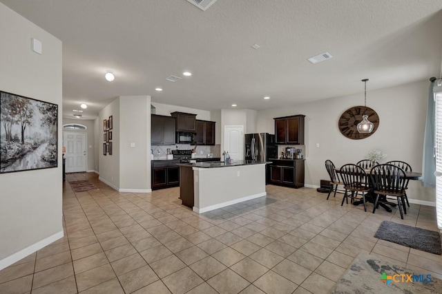 1398 Fall Cover St, New Braunfels, TX 78130 - kitchen featuring light tile patterned floors, black appliances, dark brown cabinetry, tasteful backsplash, and a center island with sink