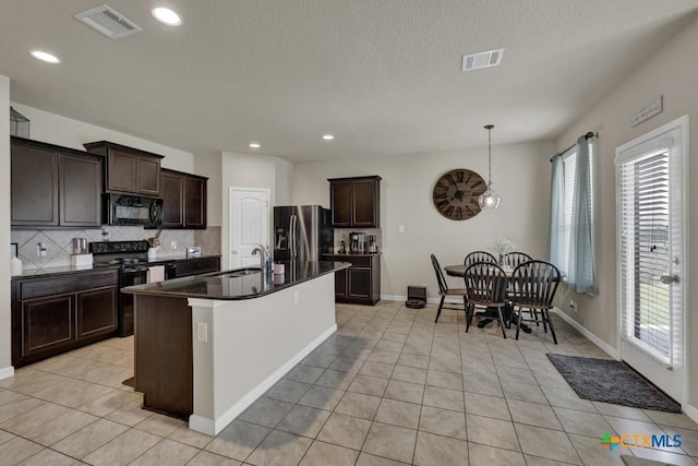 1398 Fall Cover St, New Braunfels, TX 78130 - kitchen with black appliances, dark countertops, tasteful backsplash, dark brown cabinetry, and recessed lighting
