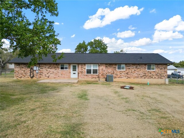 view of front of home featuring a front yard, central AC, and a patio area