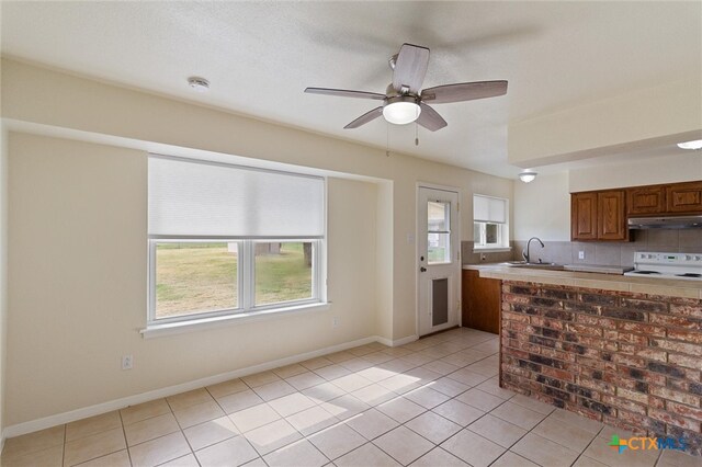 kitchen with white range, sink, ceiling fan, tasteful backsplash, and light tile patterned flooring