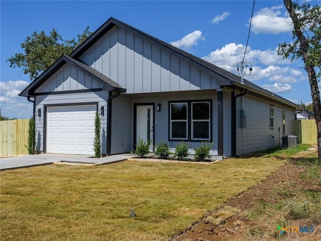 view of front of property featuring a garage, a front yard, and central AC unit