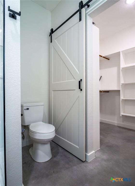 307 Cedarhill Dr, Granite Shoals, TX 78654 - bathroom featuring finished concrete flooring, baseboards, and toilet