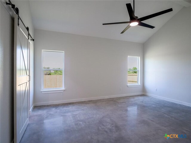 307 Cedarhill Dr, Granite Shoals, TX 78654 - empty room with a healthy amount of sunlight, concrete flooring, vaulted ceiling, and a barn door