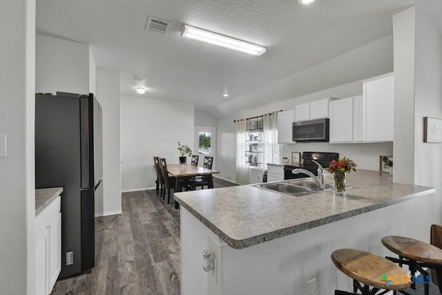 2328 Arctic Warbler, New Braunfels, TX 78130 - kitchen with black appliances, a sink, a peninsula, a kitchen bar, and lofted ceiling