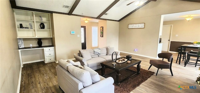 living room featuring hardwood / wood-style floors, lofted ceiling with beams, and ceiling fan