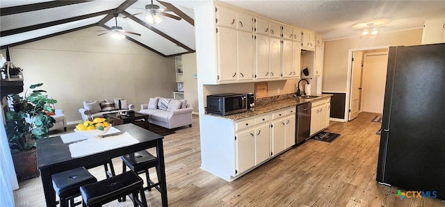 kitchen featuring sink, appliances with stainless steel finishes, ceiling fan, dark stone counters, and light hardwood / wood-style floors