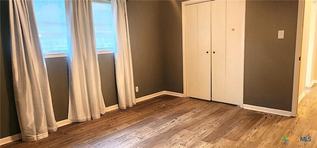 unfurnished bedroom with hardwood / wood-style flooring and a closet