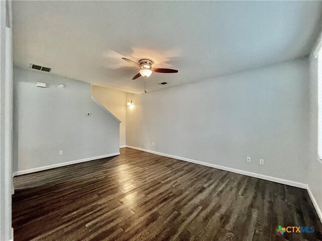 110 Rush Hvn, San Marcos, TX 78666 - unfurnished living room featuring a ceiling fan, dark wood-style flooring, baseboards, and visible vents