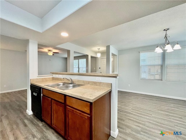 110 Rush Hvn, San Marcos, TX 78666 - kitchen featuring a peninsula, light wood-style flooring, a sink, black dishwasher, and baseboards