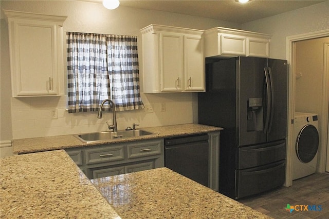 kitchen with white cabinetry, sink, black appliances, and washer / dryer