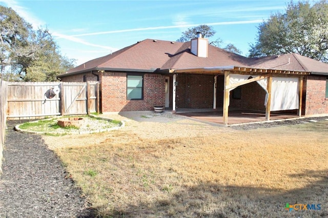 back of property featuring a patio area and a yard