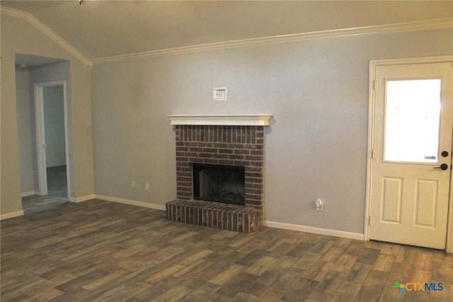 unfurnished living room with a brick fireplace, dark hardwood / wood-style flooring, ornamental molding, and vaulted ceiling