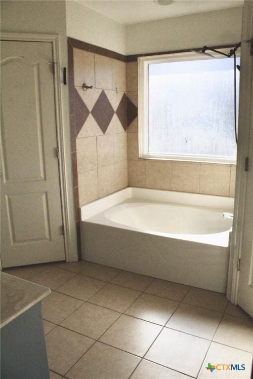 bathroom with tile patterned floors and a washtub