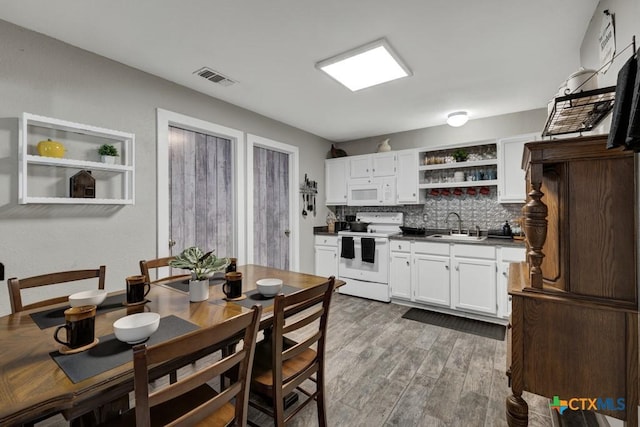 332 W Klein St, Seguin, TX 78155 - kitchen featuring white appliances, open shelves, dark countertops, white cabinetry, and backsplash