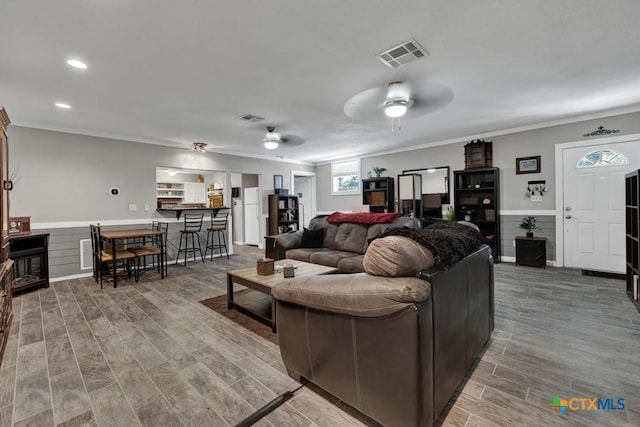 332 W Klein St, Seguin, TX 78155 - living area with light wood-type flooring, ornamental molding, ceiling fan, a wainscoted wall, and recessed lighting