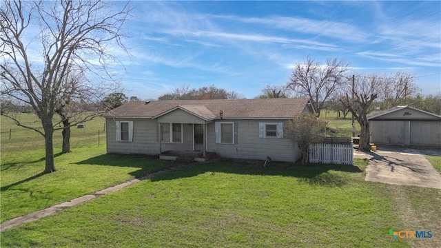 single story home featuring an outbuilding, a front yard, and a garage