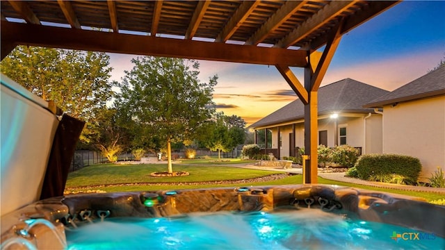 pool at dusk with a lawn, fence, and a pergola