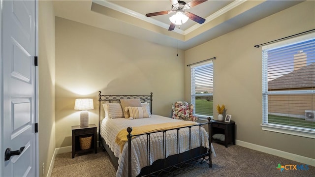 bedroom featuring carpet floors, ornamental molding, a raised ceiling, and baseboards