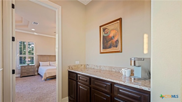 ensuite bathroom featuring ornamental molding, connected bathroom, and visible vents