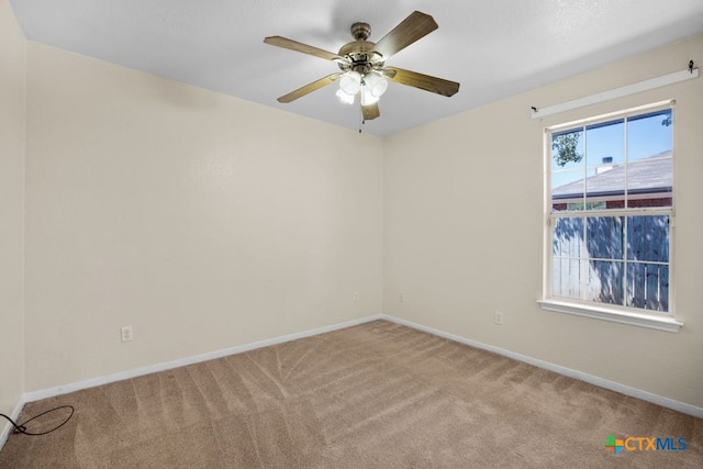 carpeted spare room featuring ceiling fan