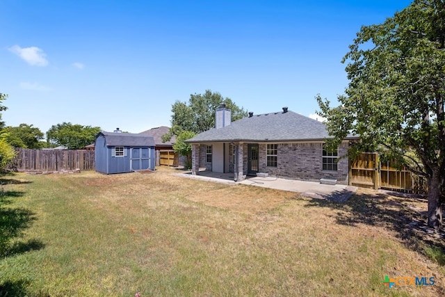 back of property with a storage shed, a yard, and a patio area